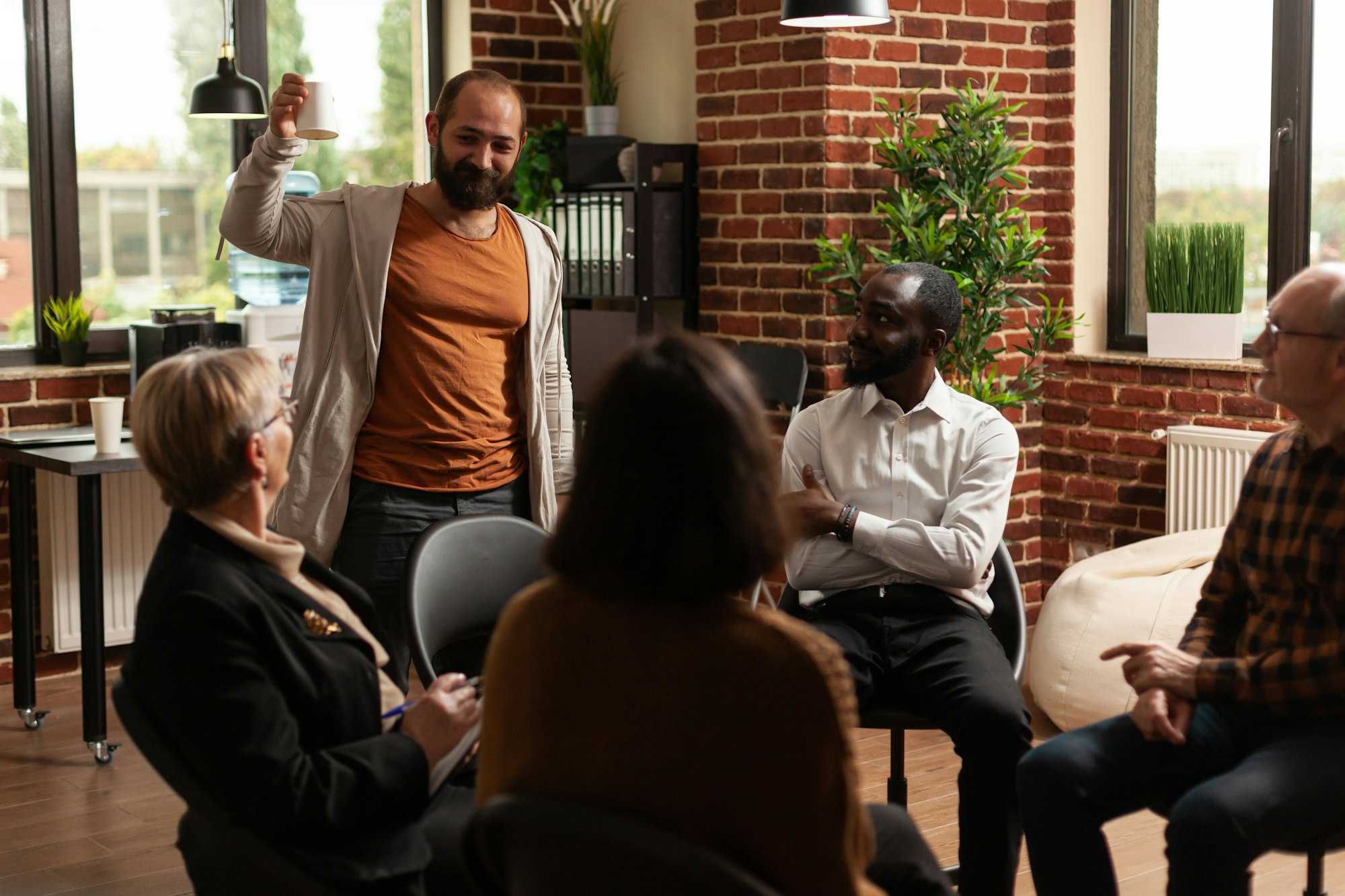 Man talking about achievement with people at aa group meeting session